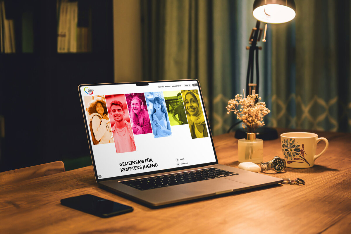 Mockup Laptop mit der Website des Stadtjugendrings Kempten auf einem Holztisch.