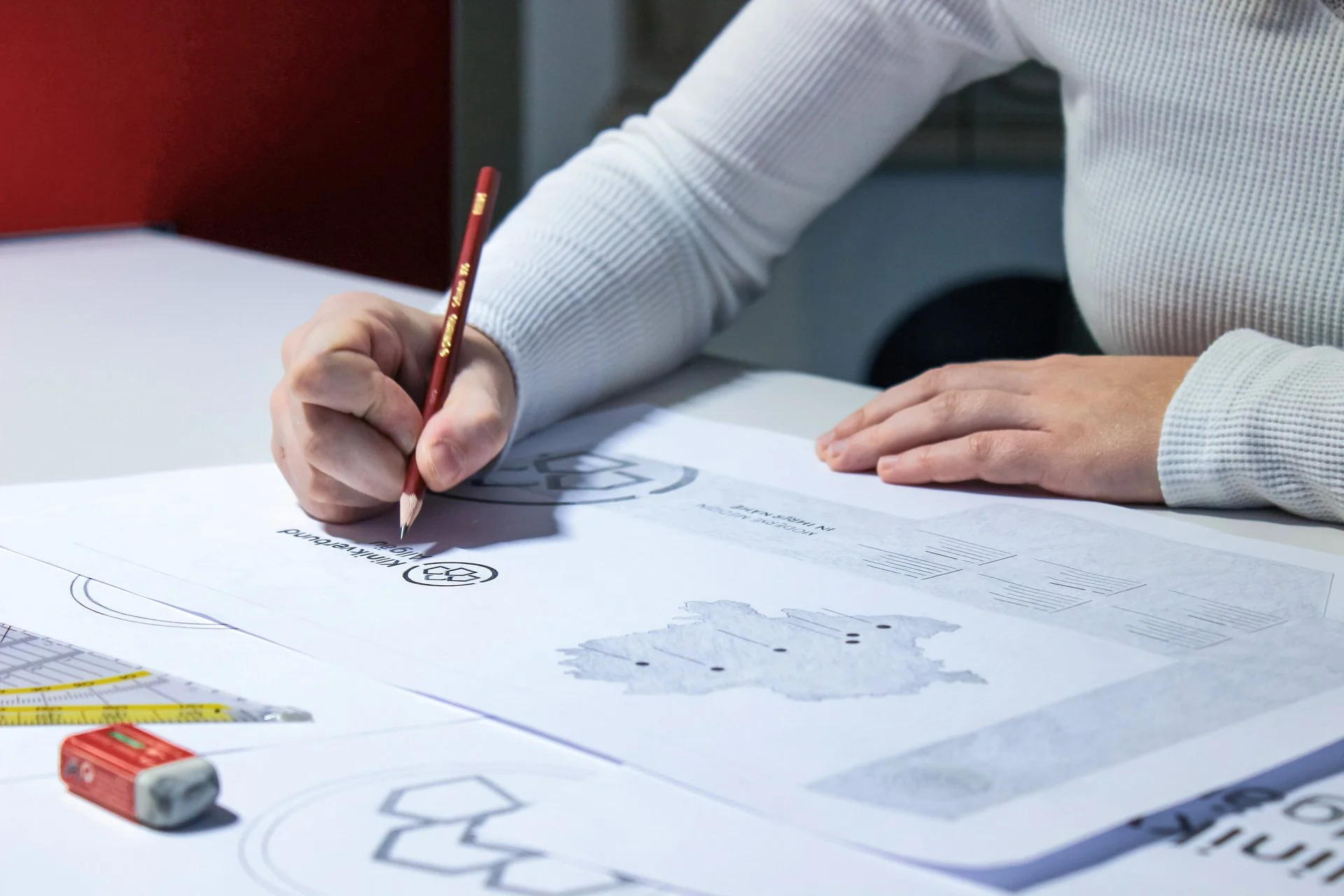 WE CREATE<br/>BRAND LEADER Hand zeichnet Logoentwurf auf Papier – kreative Markenentwicklung bei der Denkströme