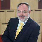 Geschäftsporträt von Alexander Schwägerl im Anzug mit gelber Krawatte, aufgenommen in modernem Büroambiente – zufriedener Kunde der Agentur