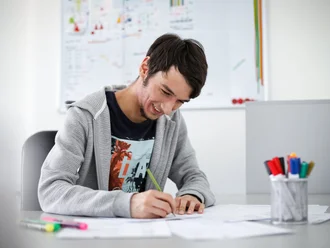 Junger Denkströme Grafiker arbeitet konzentriert an Markendesigns im kreativen Büro der Denkströme Gruppe